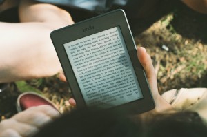 Person reading Kindle Ereader outside, by James Tarbotten on stocksnap.io