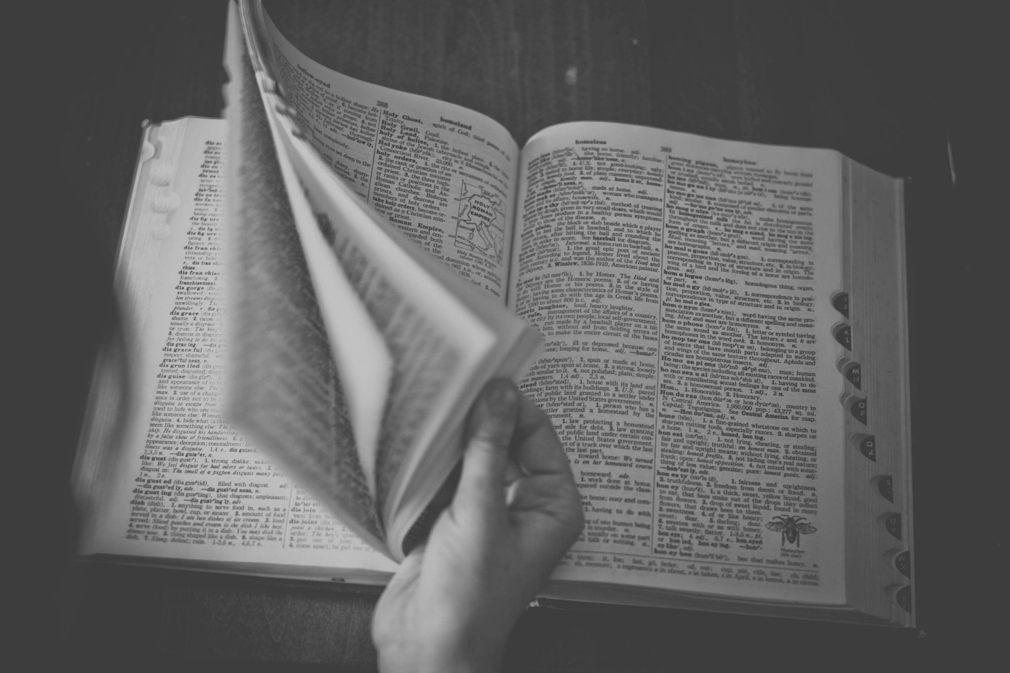 B/W photo of person leafing through dictionary by Sonja Langford from stocksnap.io