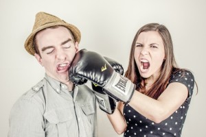 Female wearing boxing gloves hitting a man in a hat by Ryan McGuire from stocksnap.io