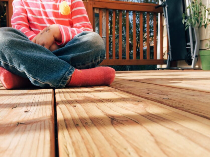 Child sitting on wooden deck by Jeri Johnson from stocksnap.io
