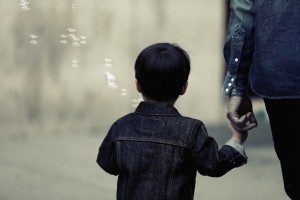 Kid with bubbles holding adult's hand by Leeroy from stocksnap.io