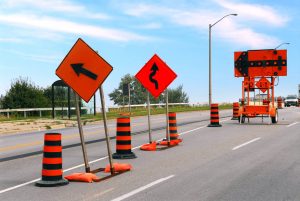 Road construction signs and cones on a city street