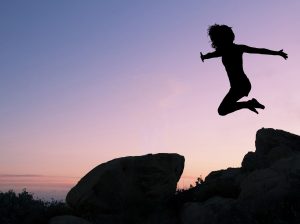 Person leaping across the sky at dusk