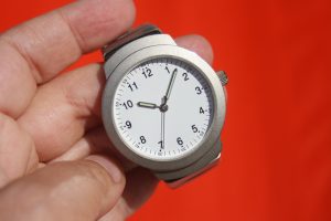 Man holding a watch with a red background