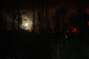 View of the night sky with lava glow and moon in lower Puna, Hawaii Island, on May 30, 2018