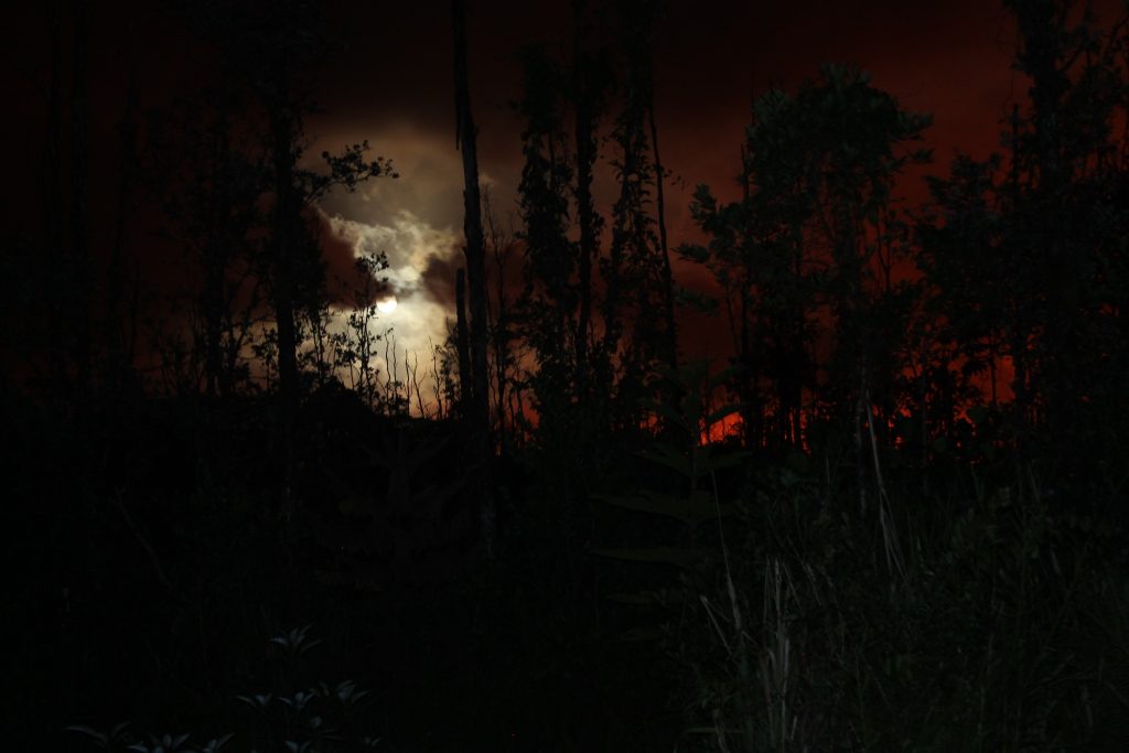 View of the night sky with lava glow and moon in lower Puna, Hawaii Island, on May 30, 2018