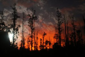 View of the night sky with lava glow and moon in lower Puna, Hawaii Island, on May 30, 2018