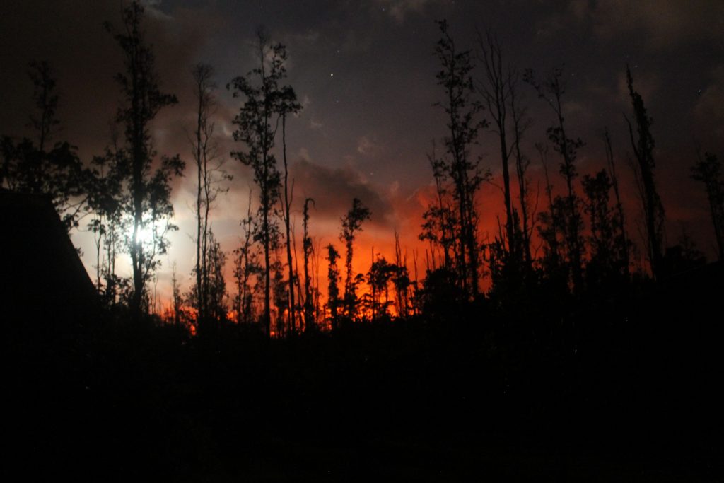 View of the night sky with lava glow and moon in lower Puna, Hawaii Island, on May 30, 2018