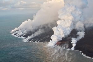 July 5, 2018 (USGS HVO, public domain) Having crusted over about 0.8 km (0.5 mi) upchannel from the ocean entry, lava oozes from the flow’s molten interior to enter the sea along a broad flow front on the northern (Kapoho) side of the flow.