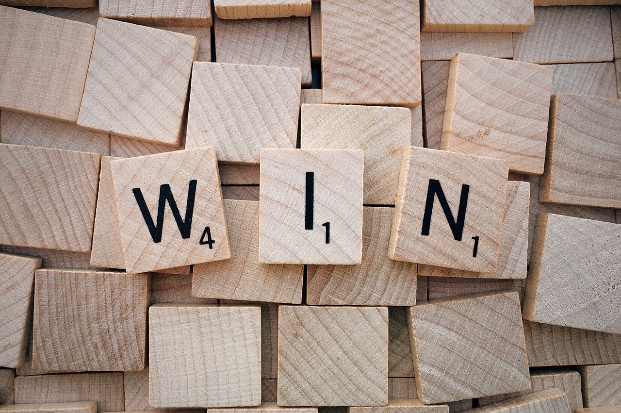 Scrabble tiles spelling "win"