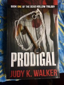 Skeleton key on a chain resting on a copy of Prodigal by Judy K. Walker