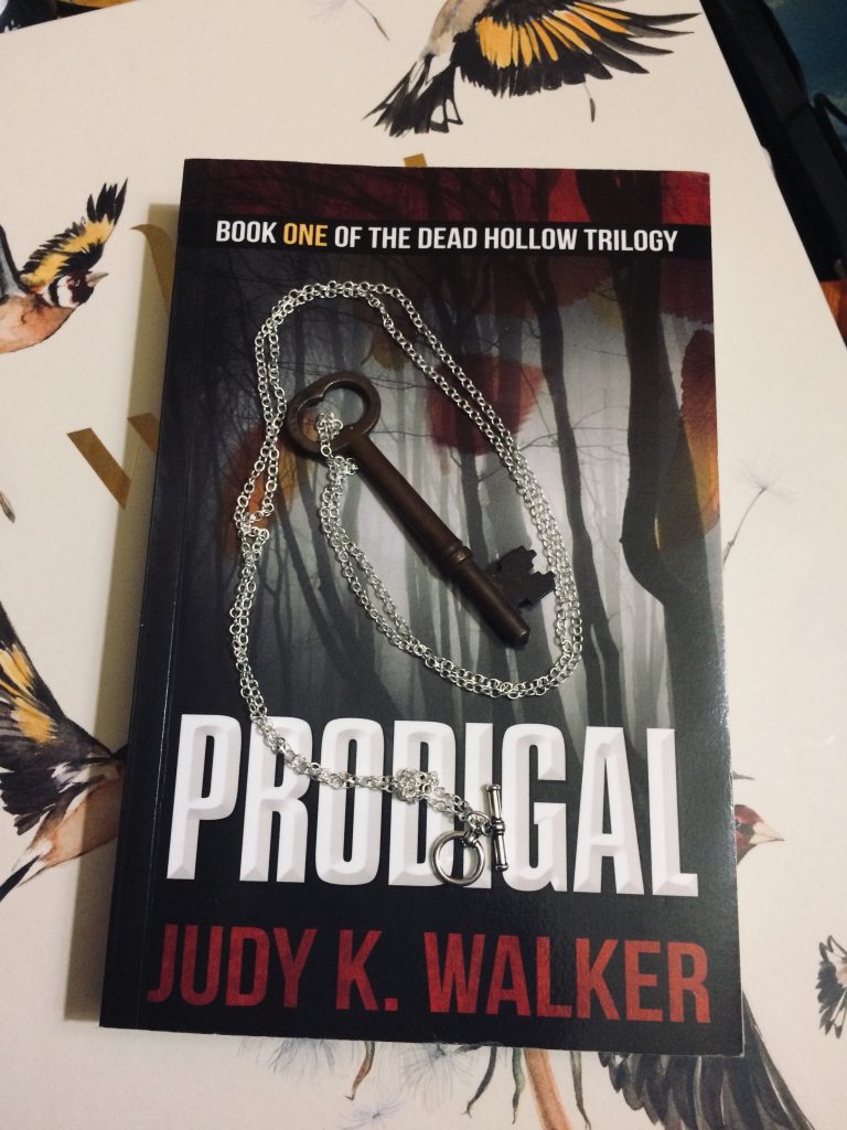 A skeleton key on a chain, resting on a copy of Prodigal, by Judy K. Walker